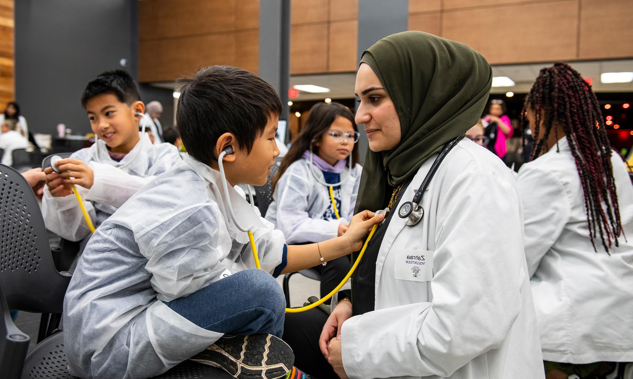 An image of an OUWB student and a Reach Out to Youth participant